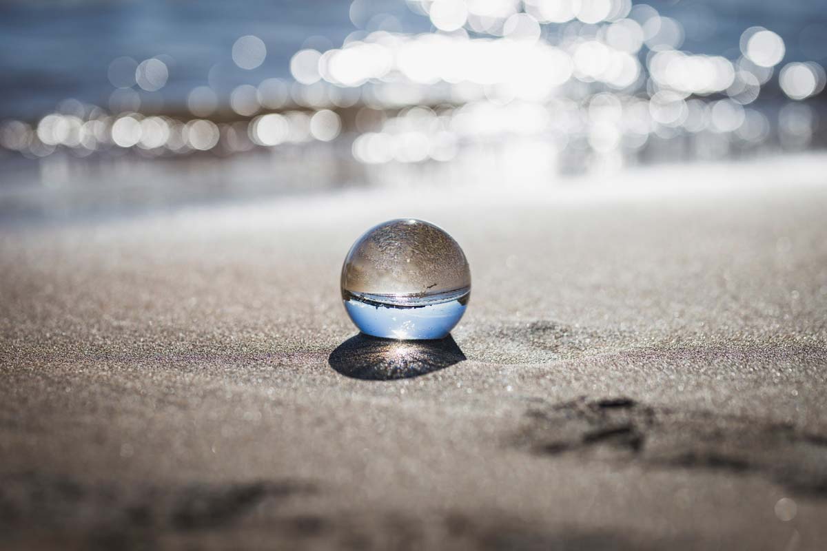 Somatic therapy creates a sense of wholeness by using mind body spirit connection represented by glass ball on beach